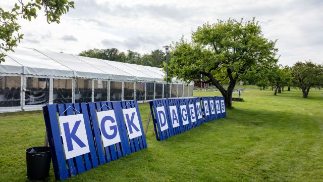 Blåmålade EU-pallar som står upprätt på gräsmatta. På pallarna bokstäver som bildar namnet KGK-dagen.